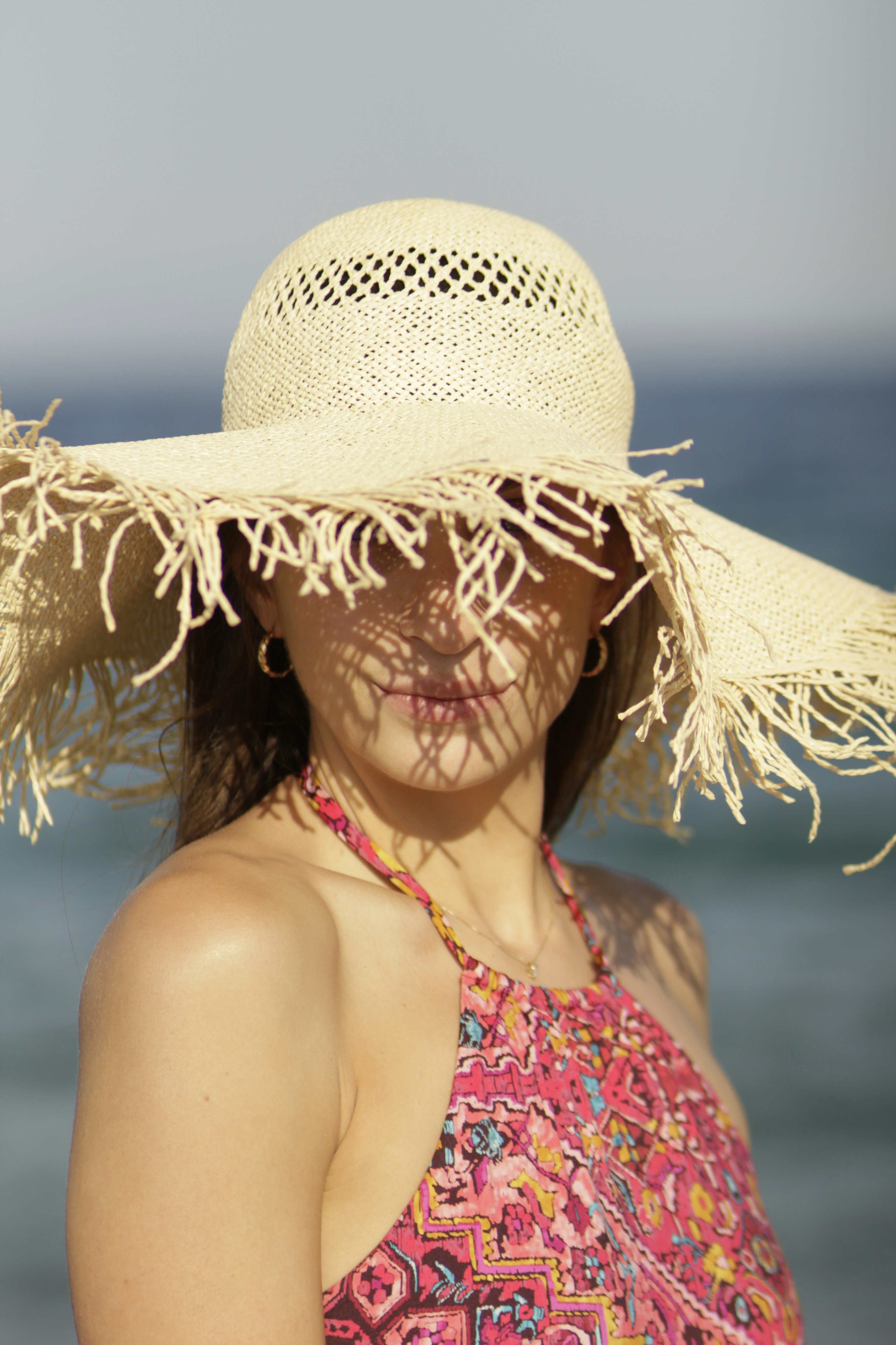 woman in red and white floral bikini top wearing brown straw hat