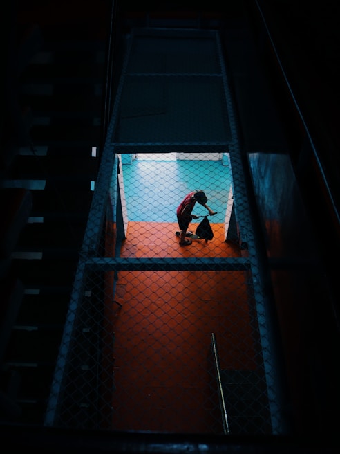 Team of Filipino workers mopping floors with bright sunlight streaming through windows