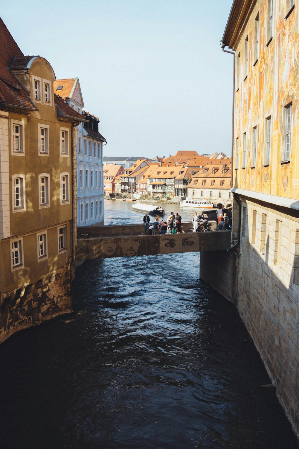 people walking on sidewalk beside river during daytime