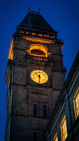 Evening shot of the university’s iconic clock tower glowing softly against a deep blue sky.