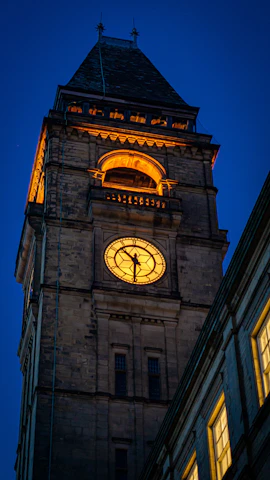 Evening shot of the university’s iconic clock tower glowing softly against a deep blue sky.