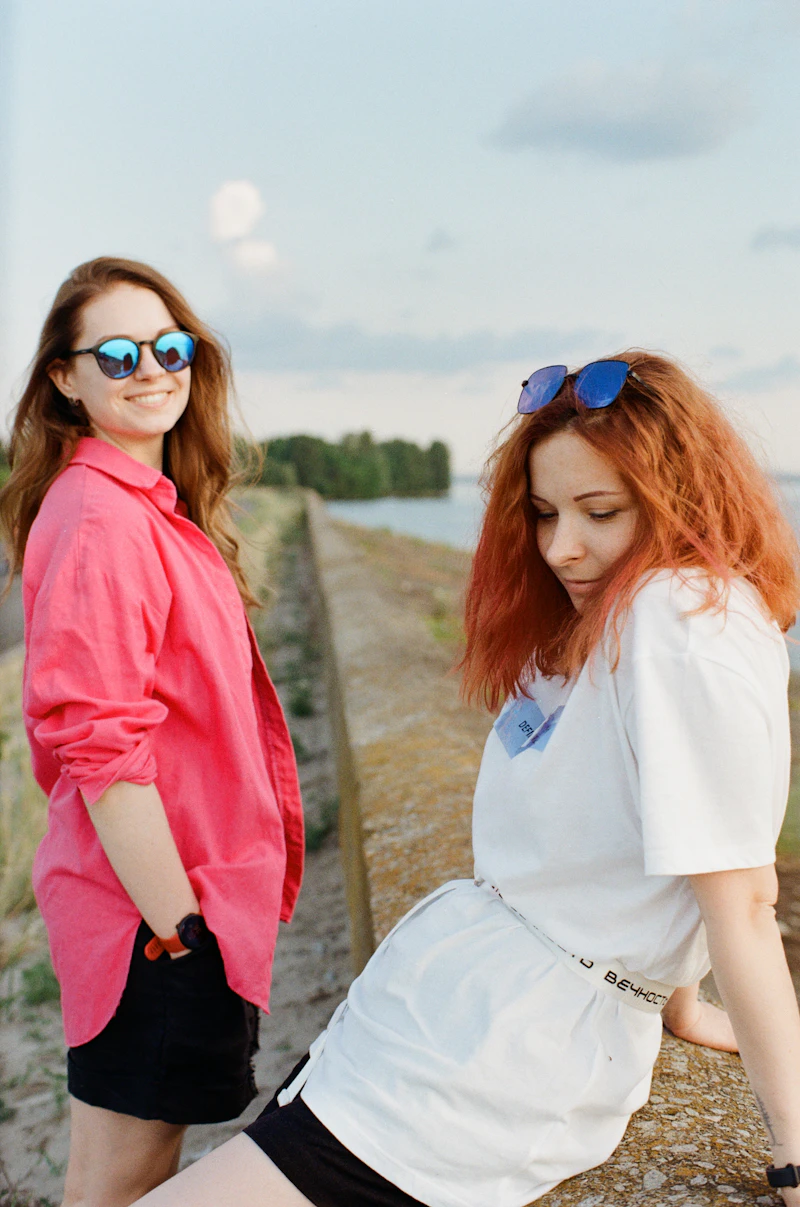 Woman in a white long-sleeve shirt and blue-framed sunglasses