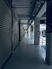 white tiled hallway with white metal doors