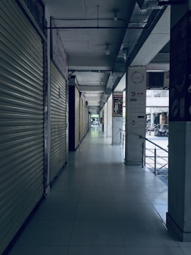white tiled hallway with white metal doors