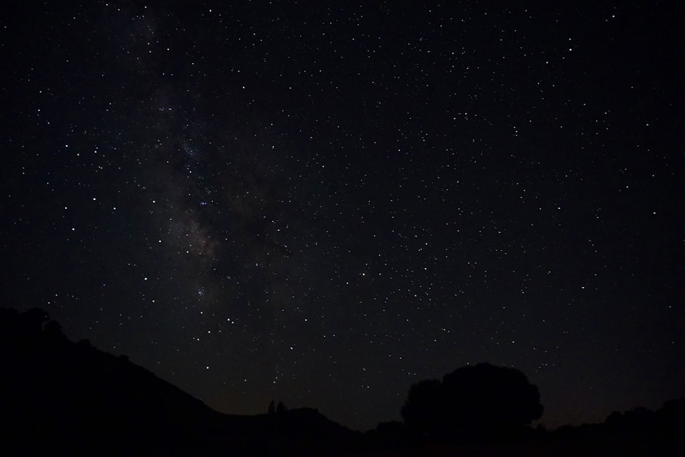 silhouette of mountain under starry night