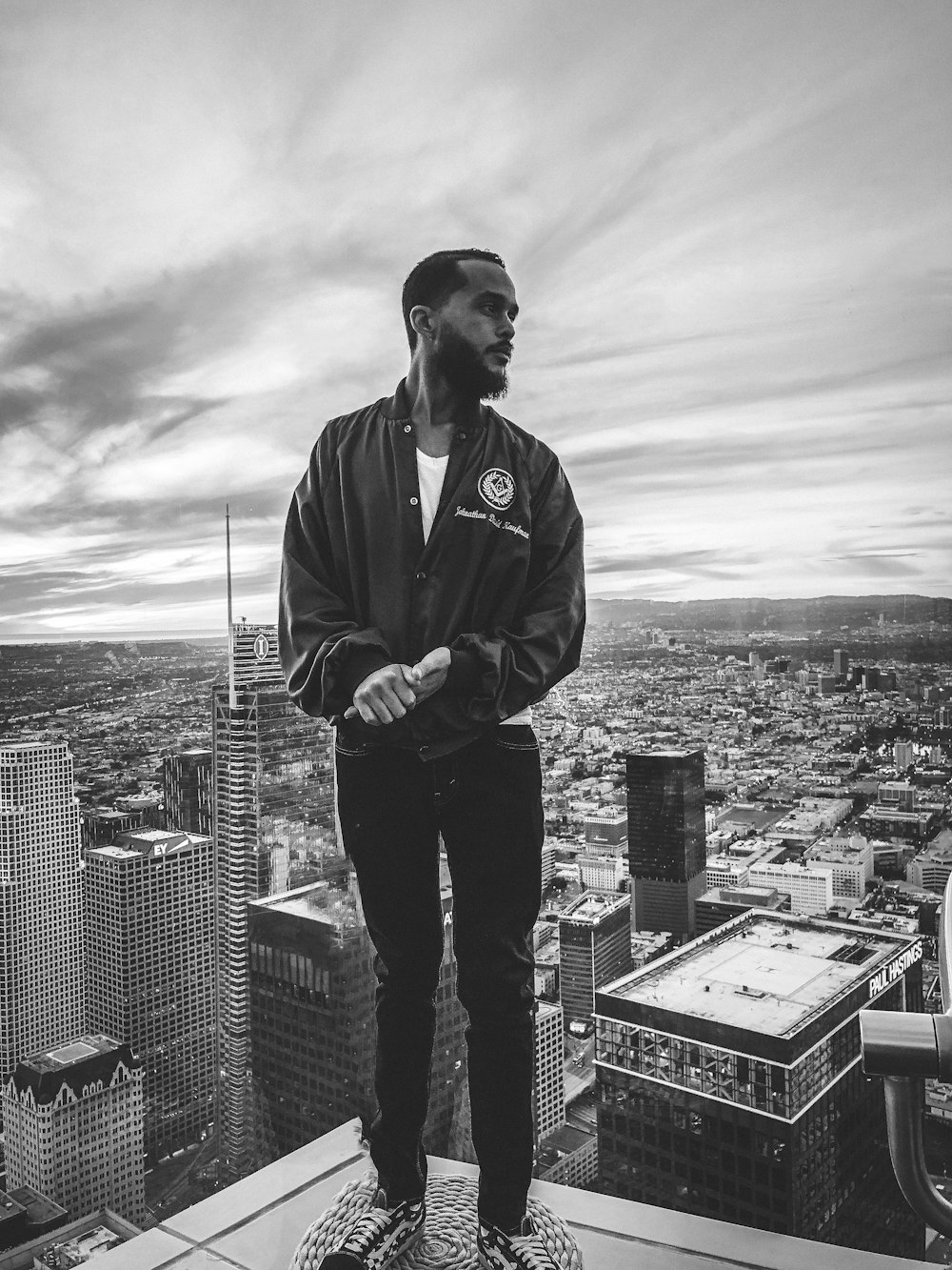 man in black jacket standing on top of building