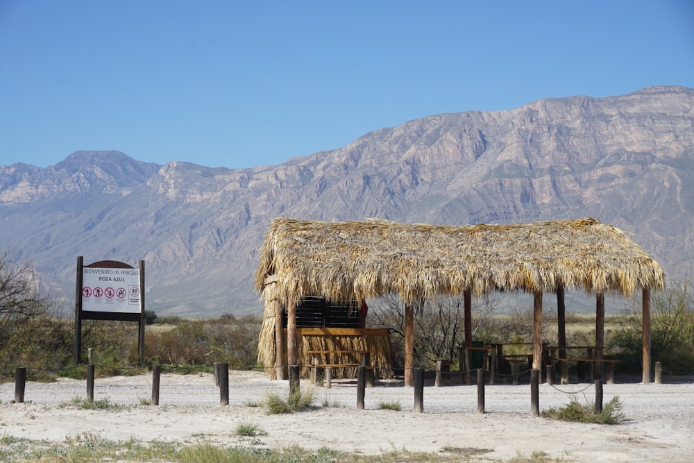 brown wooden house near brown mountain under blue sky during daytime