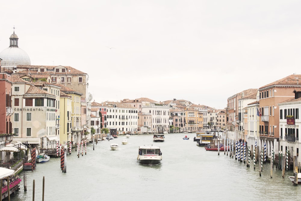 white boat on river between buildings during daytime