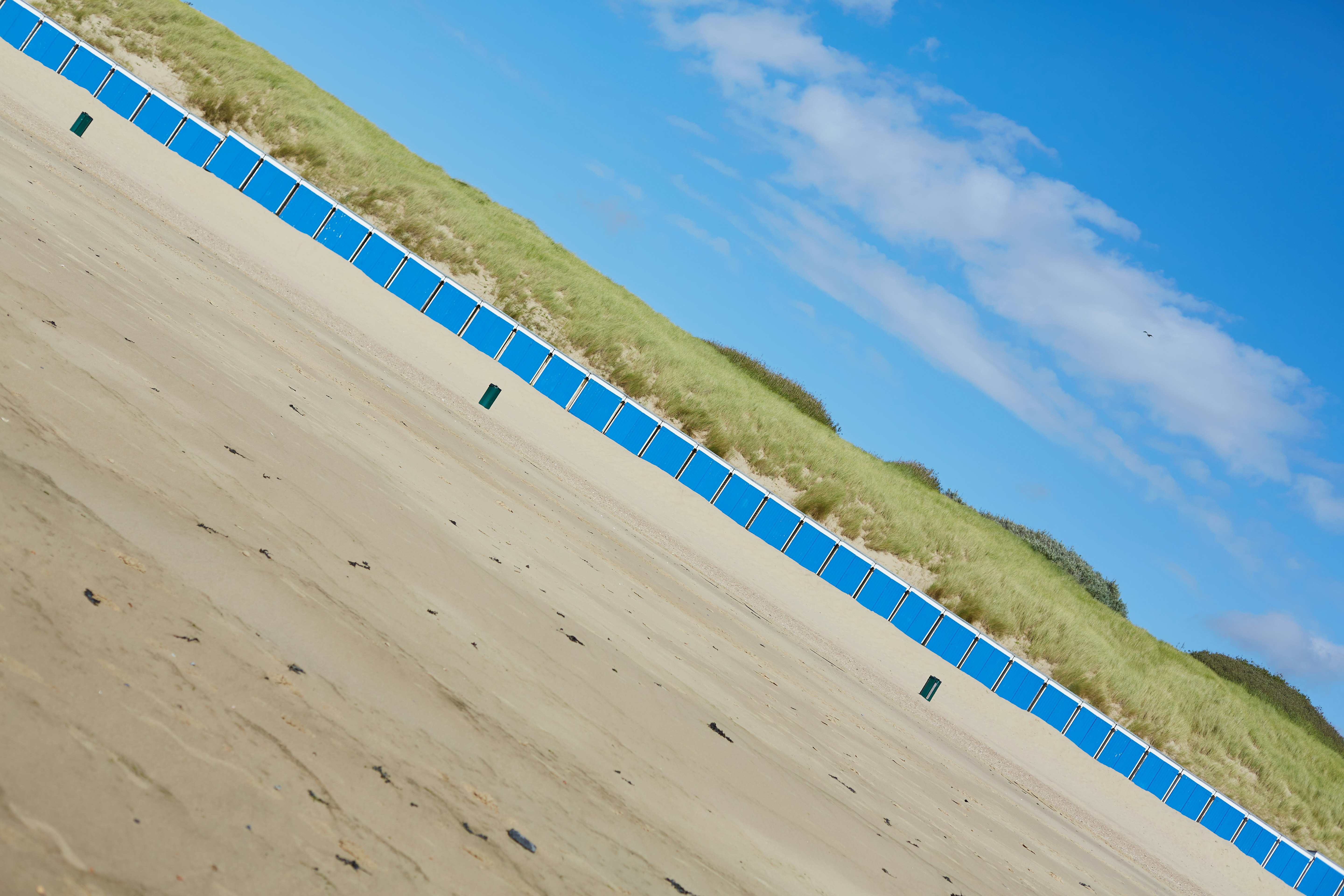 white and blue wooden fence on brown sand during daytime