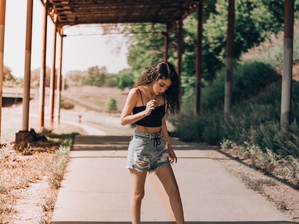 woman in gray denim shorts standing on pathway during daytime