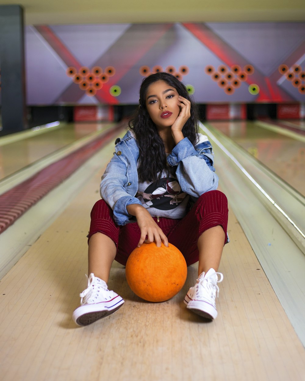 woman in blue denim jacket sitting on brown wooden floor