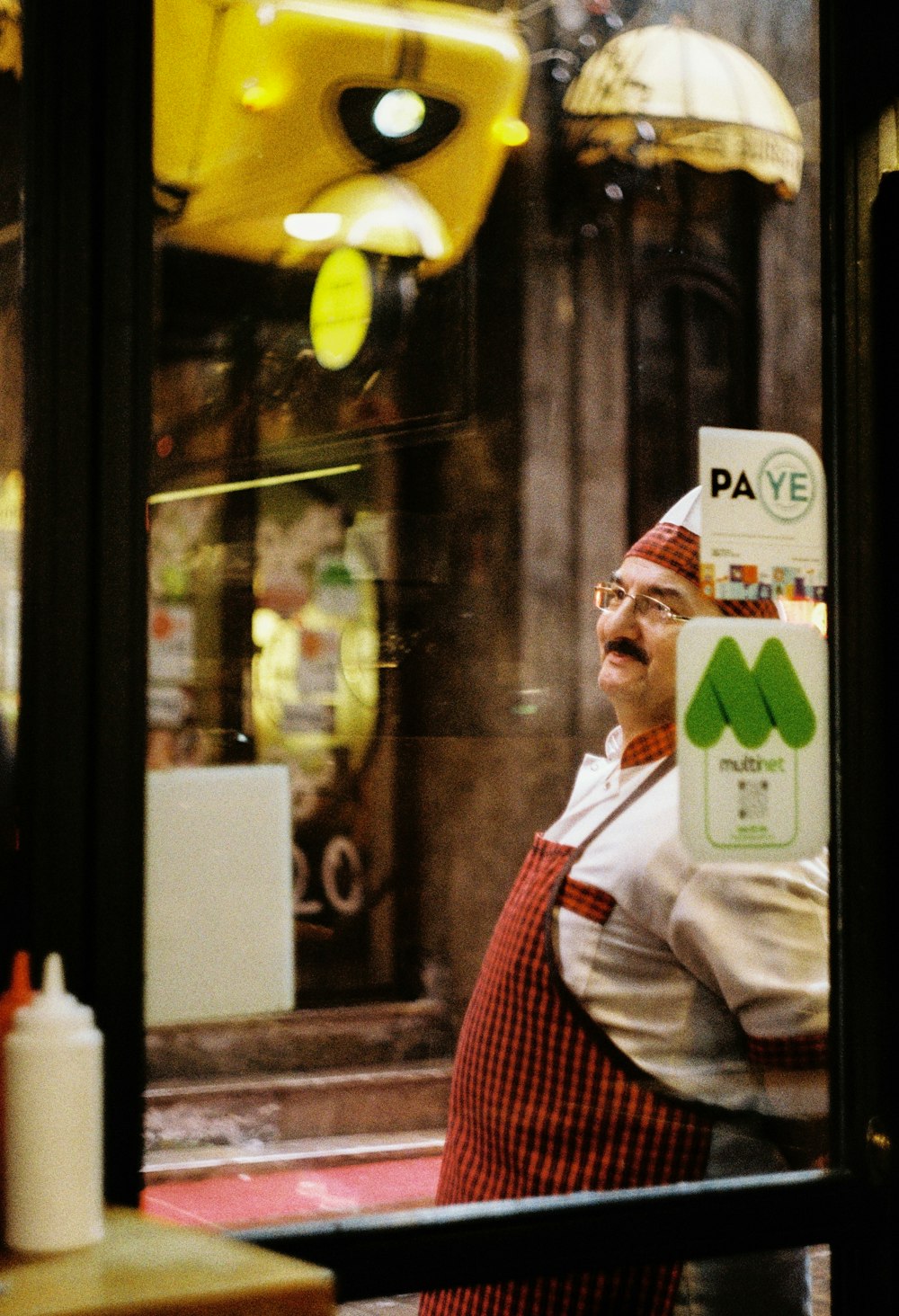 Uomo in thobe bianco in piedi vicino alla finestra di vetro