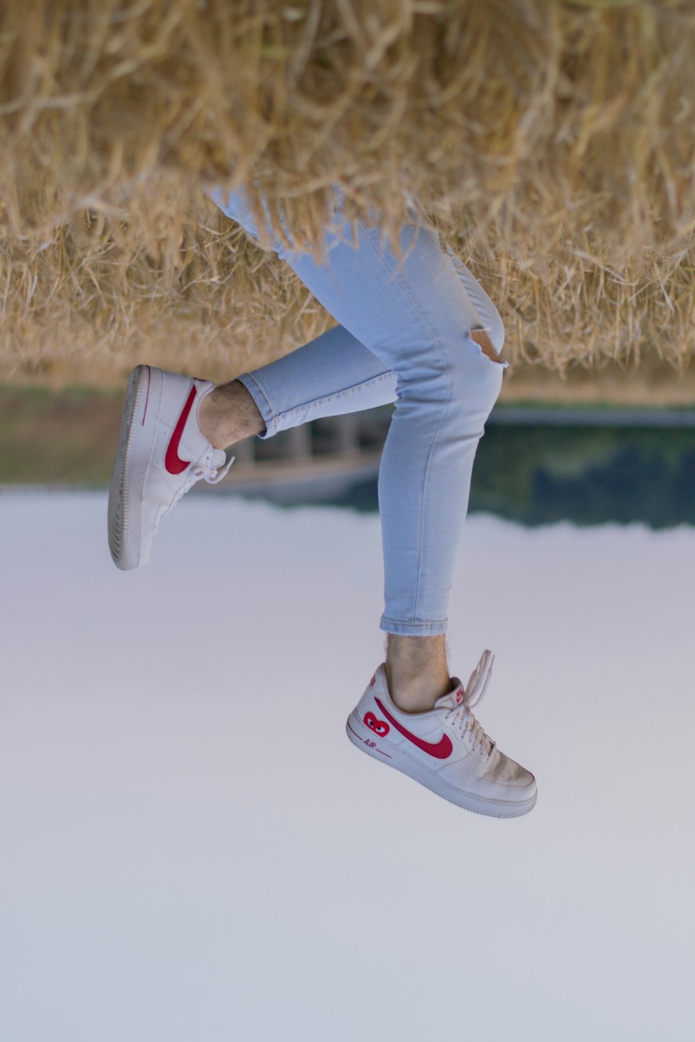 person in blue denim jeans and black and white nike sneakers