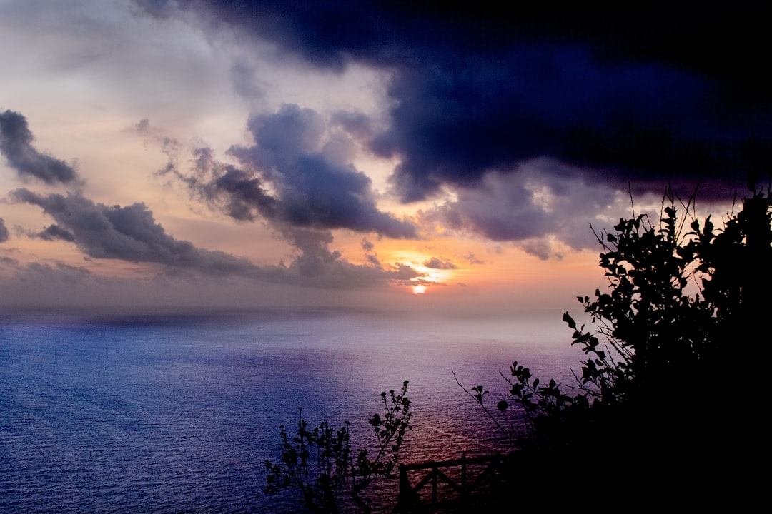 body of water under cloudy sky during sunset