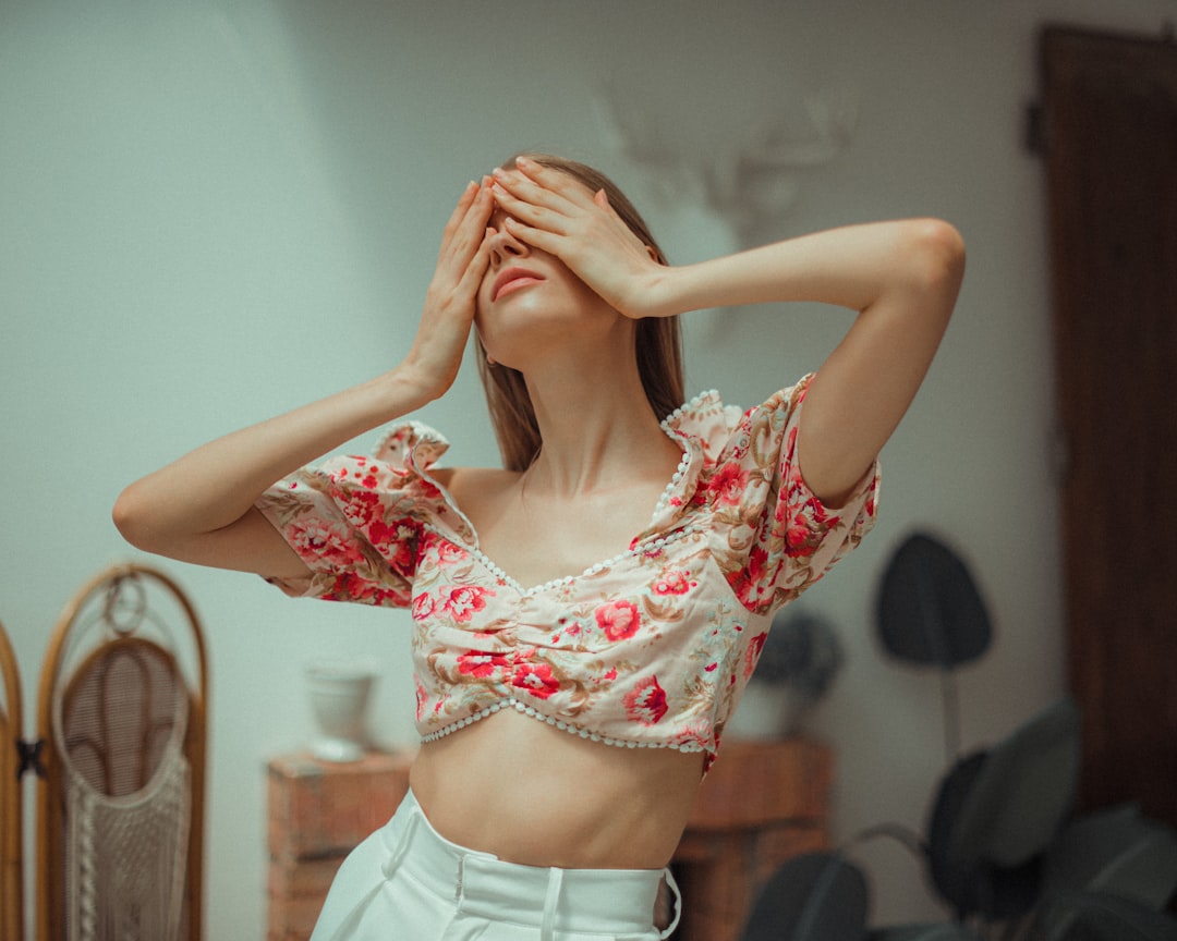 woman in red and white floral crop top and white denim shorts