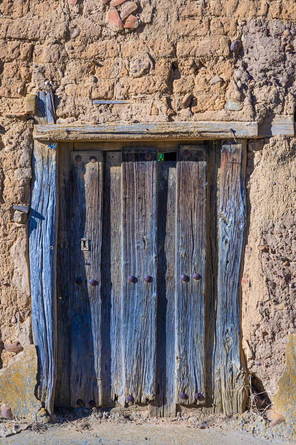Porta in legno blu con parete in cemento marrone