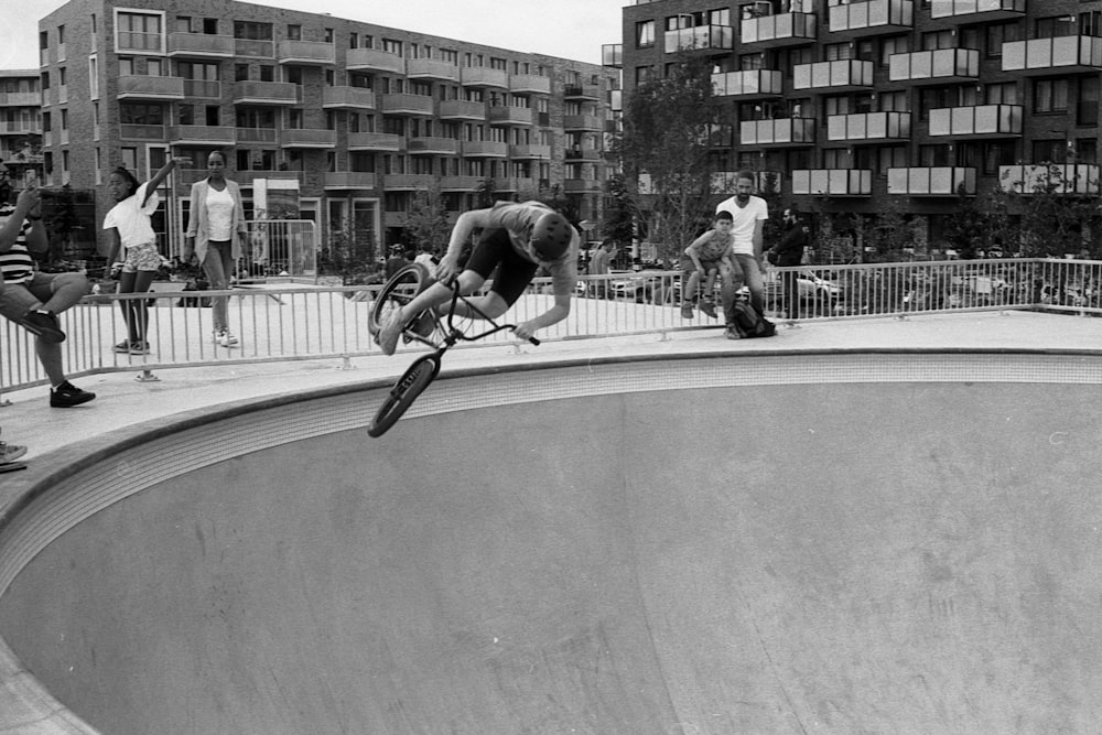 Mann auf Skateboard mitten auf der Straße in Graustufenfotografie