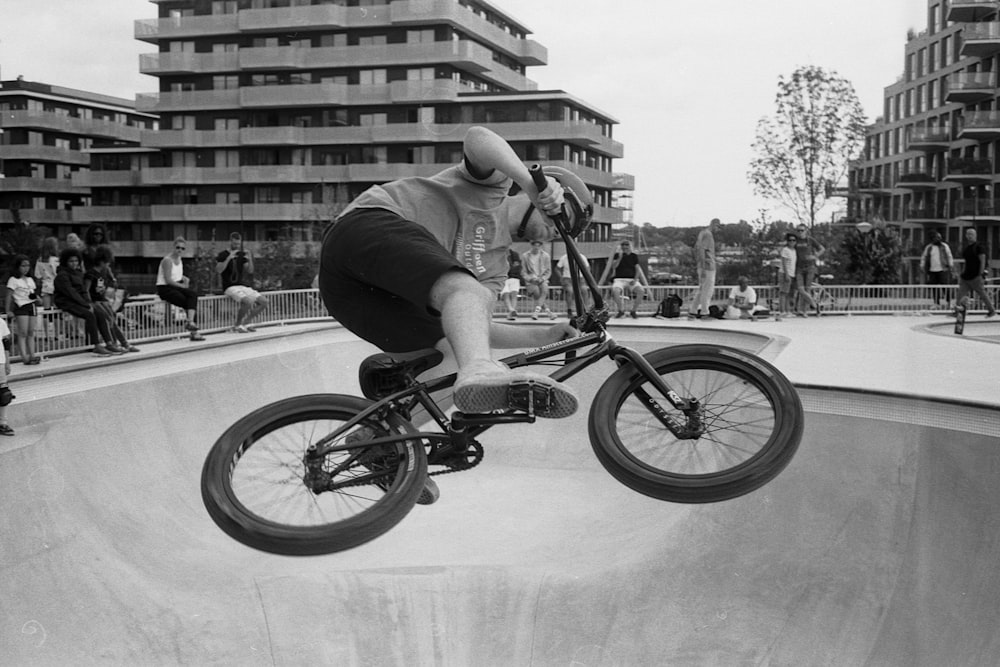 Graustufenfoto eines Mannes, der Fahrrad fährt