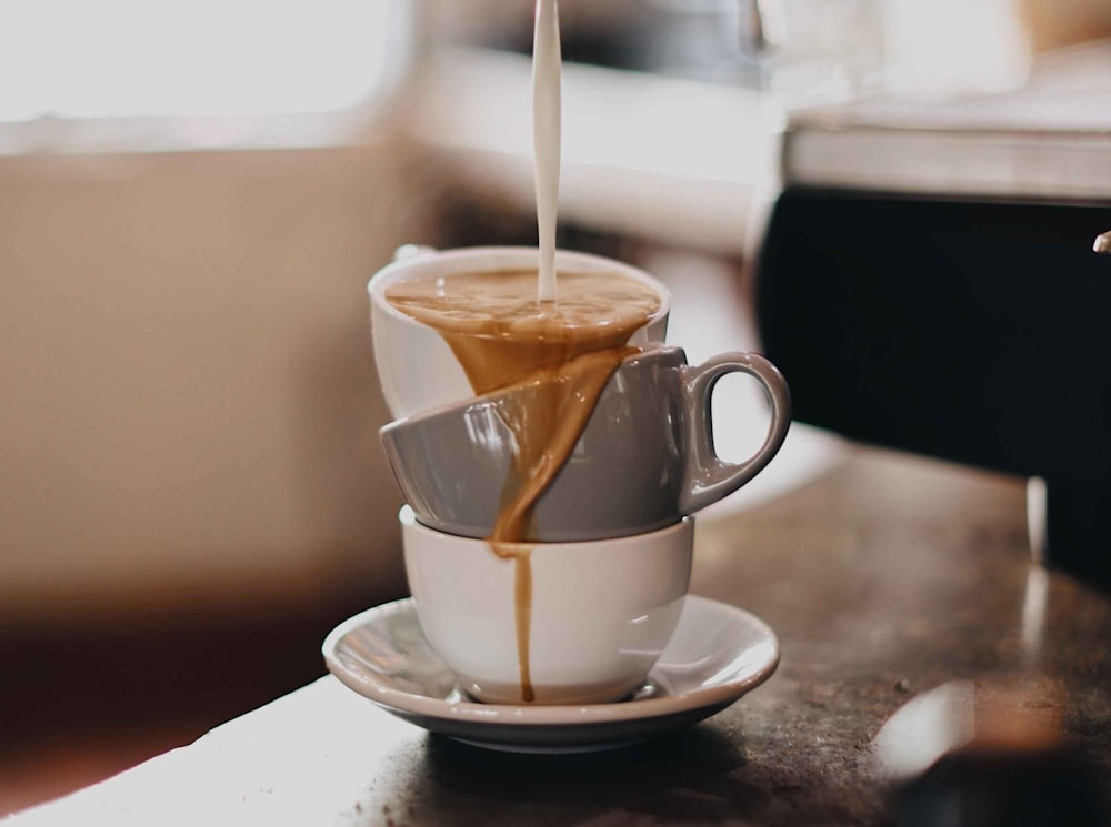 Tasse en céramique marron sur soucoupe en céramique blanche