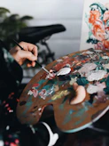 person holding paint brush while painting