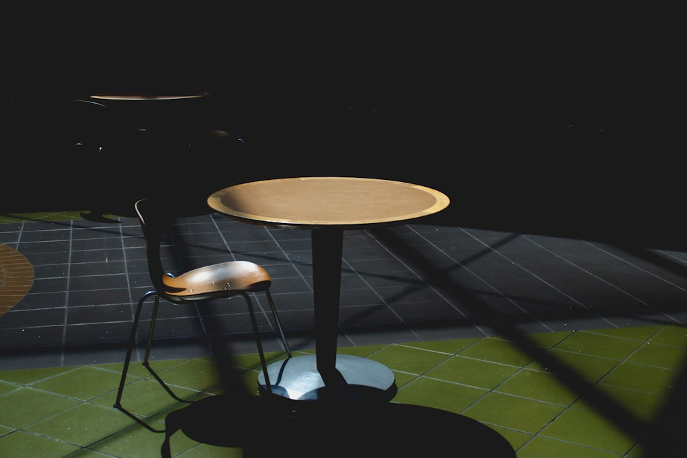 brown wooden round table on black and white checkered floor tiles