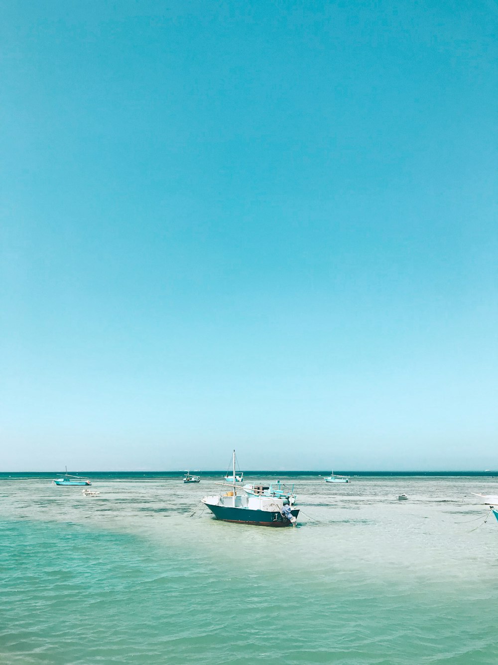 white boat on sea under blue sky during daytime