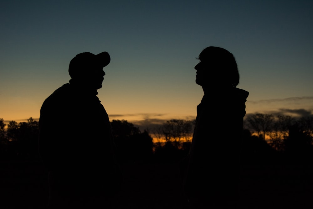 silhouette of man and woman during sunset