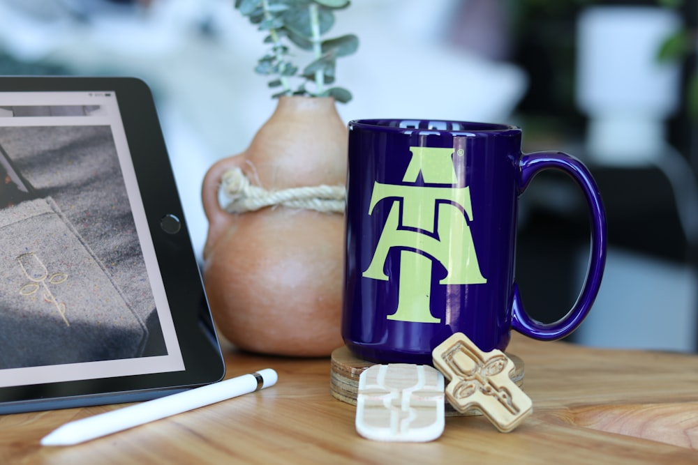 blue and white ceramic mug beside white and brown ceramic figurine