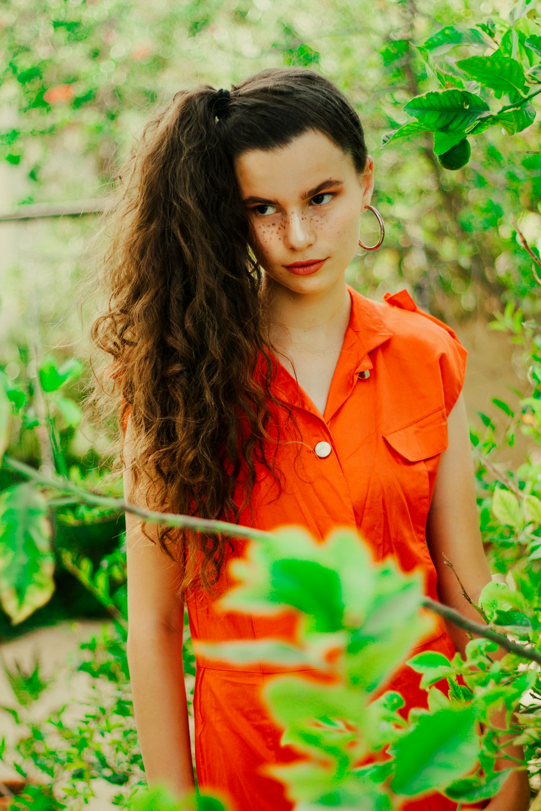 woman in red button up sleeveless shirt holding red rose