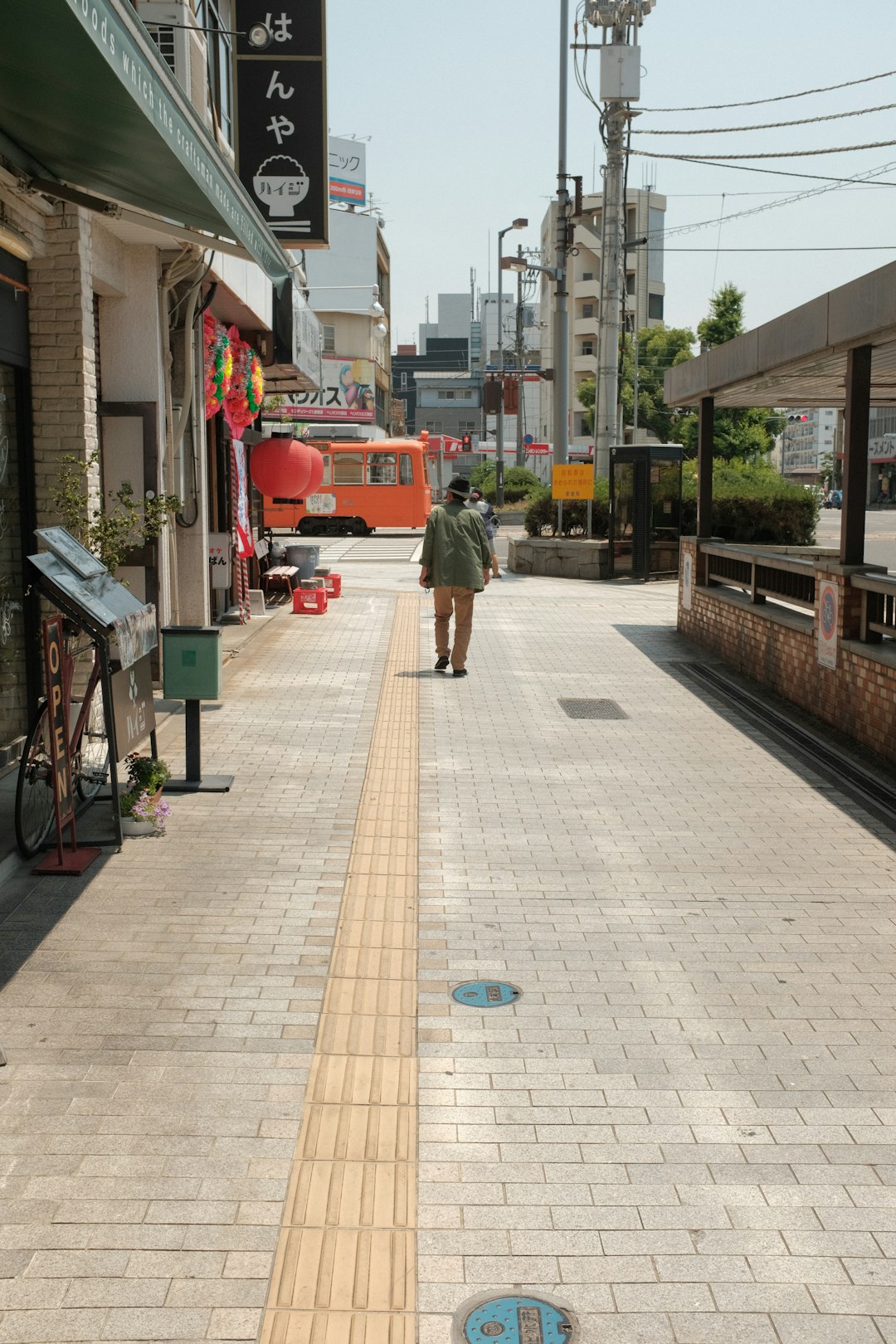 man in green jacket walking on sidewalk during daytime
