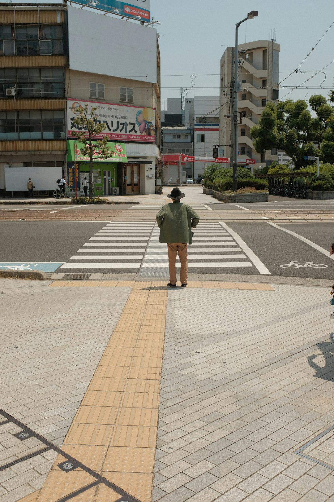 man in gray jacket walking on pedestrian lane during daytime