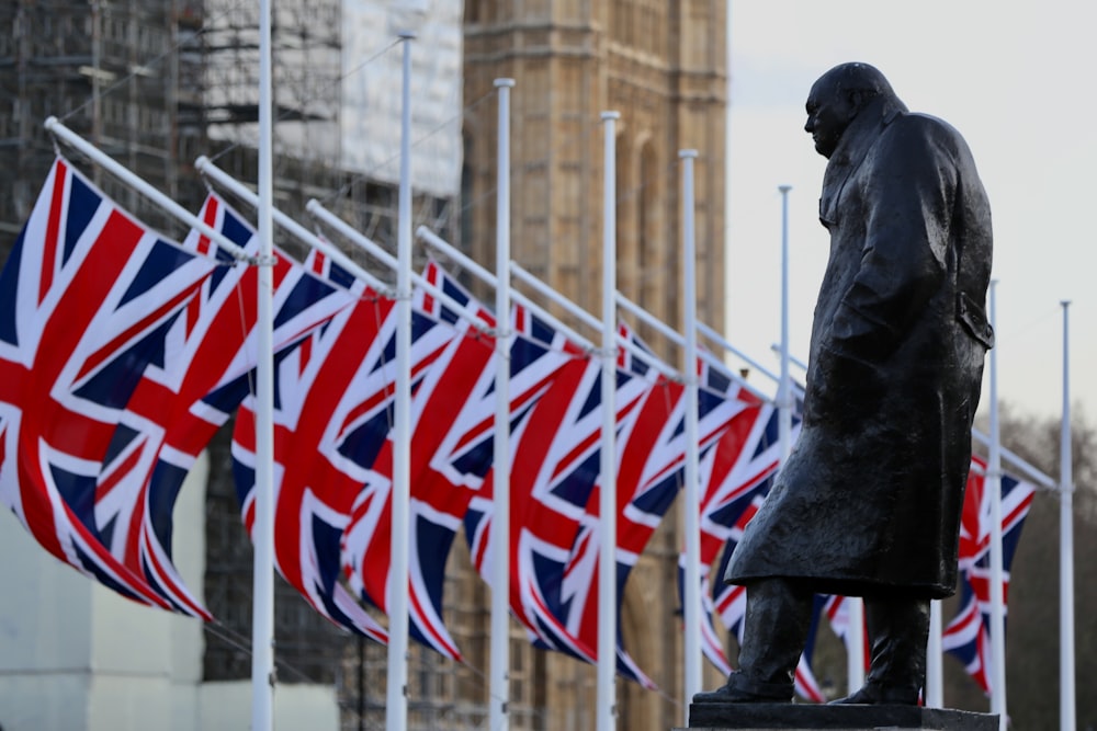 Statue eines Mannes, der tagsüber eine Flagge von uns hält