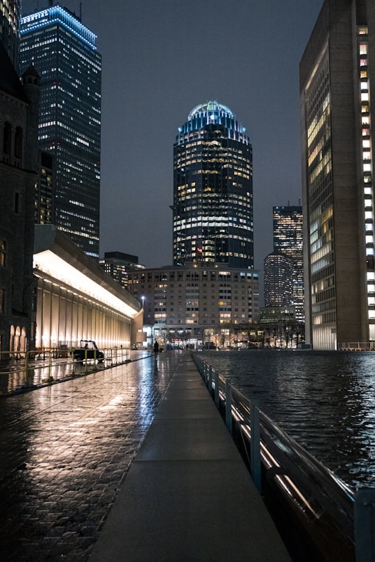 people walking on bridge near high rise buildings during night time in Boston United States