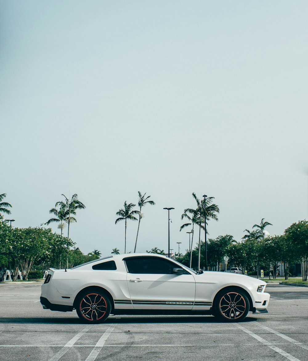 white coupe on gray asphalt road during daytime