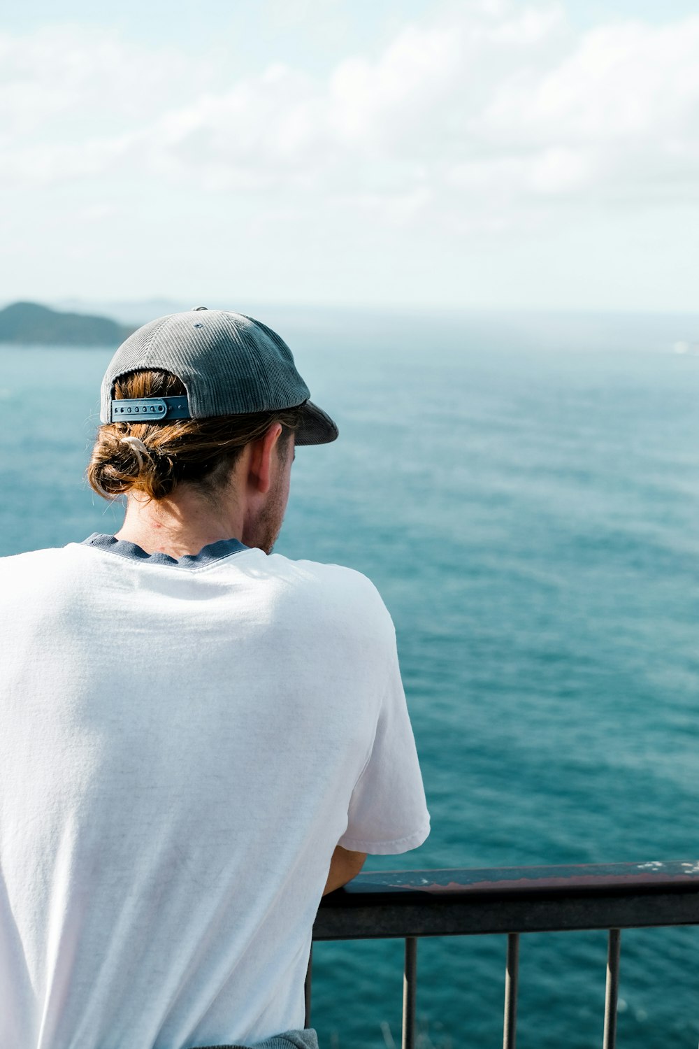 man in white shirt wearing black cap and sunglasses