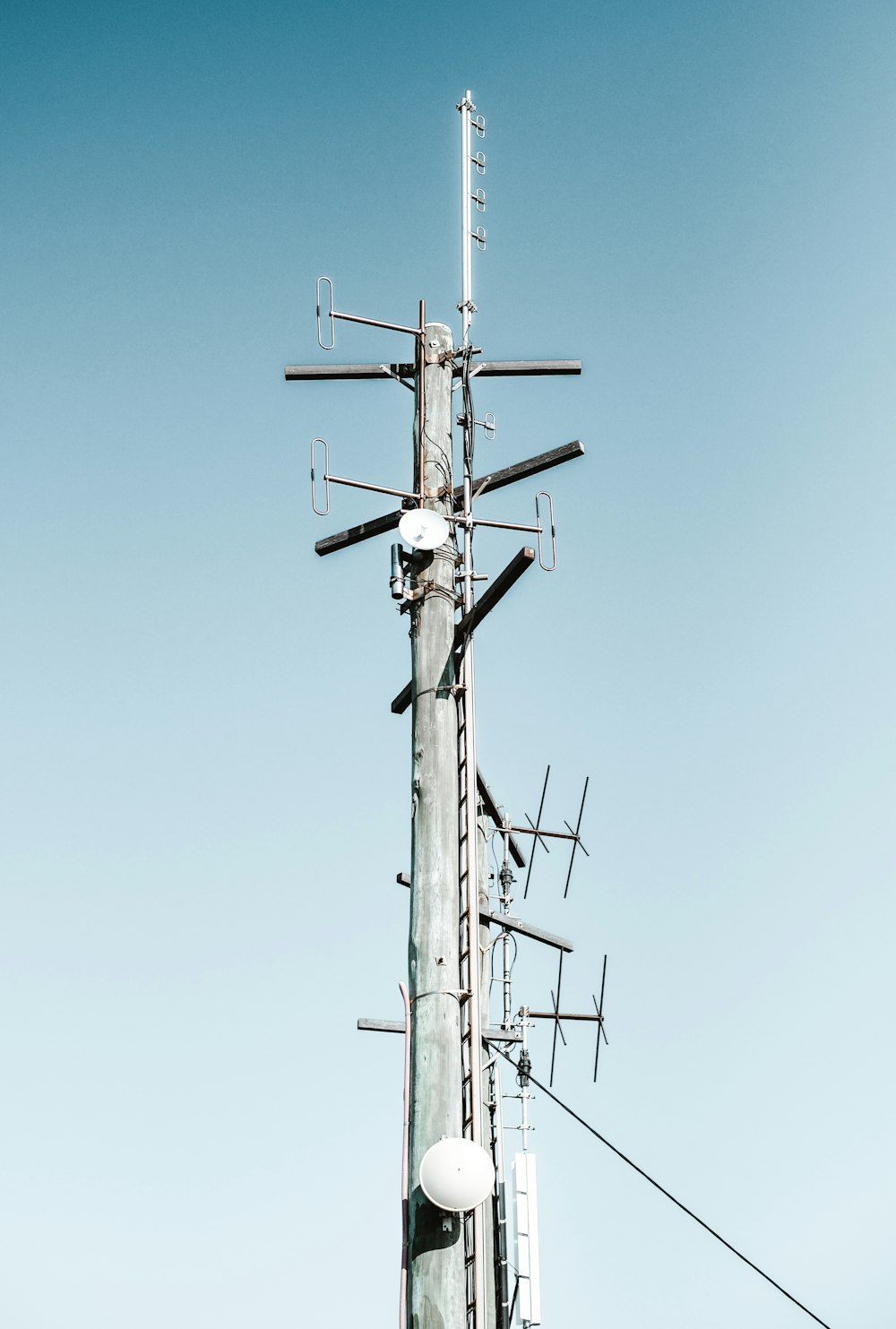 gray and white electric post under blue sky during daytime