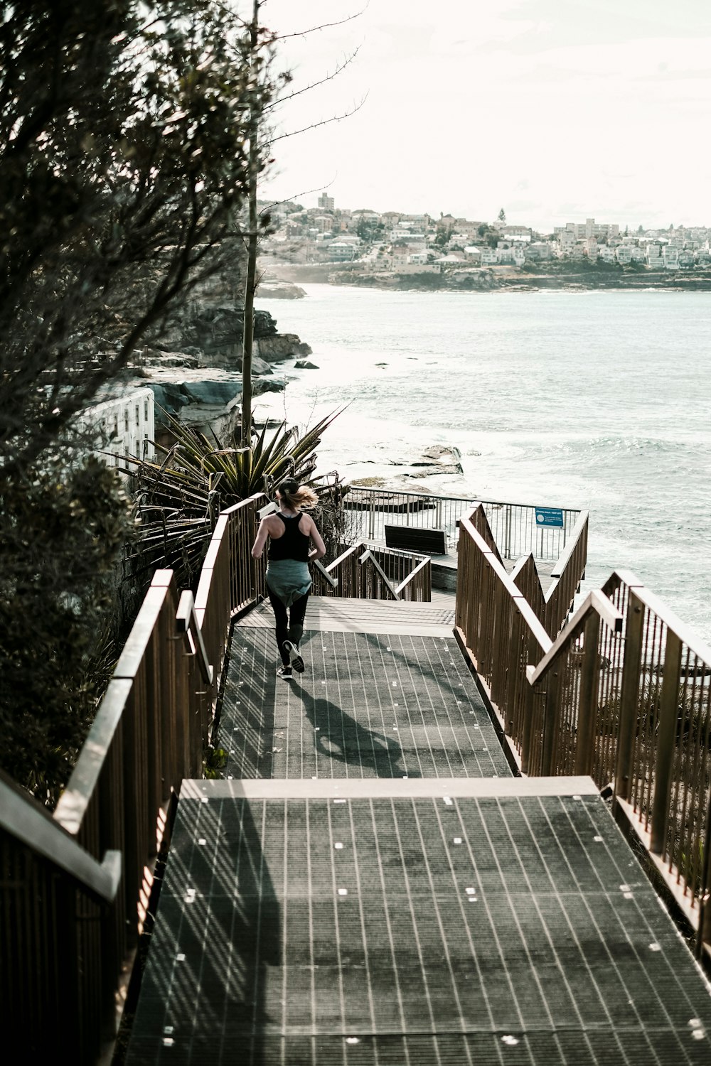 man in black t-shirt and black shorts walking on wooden dock