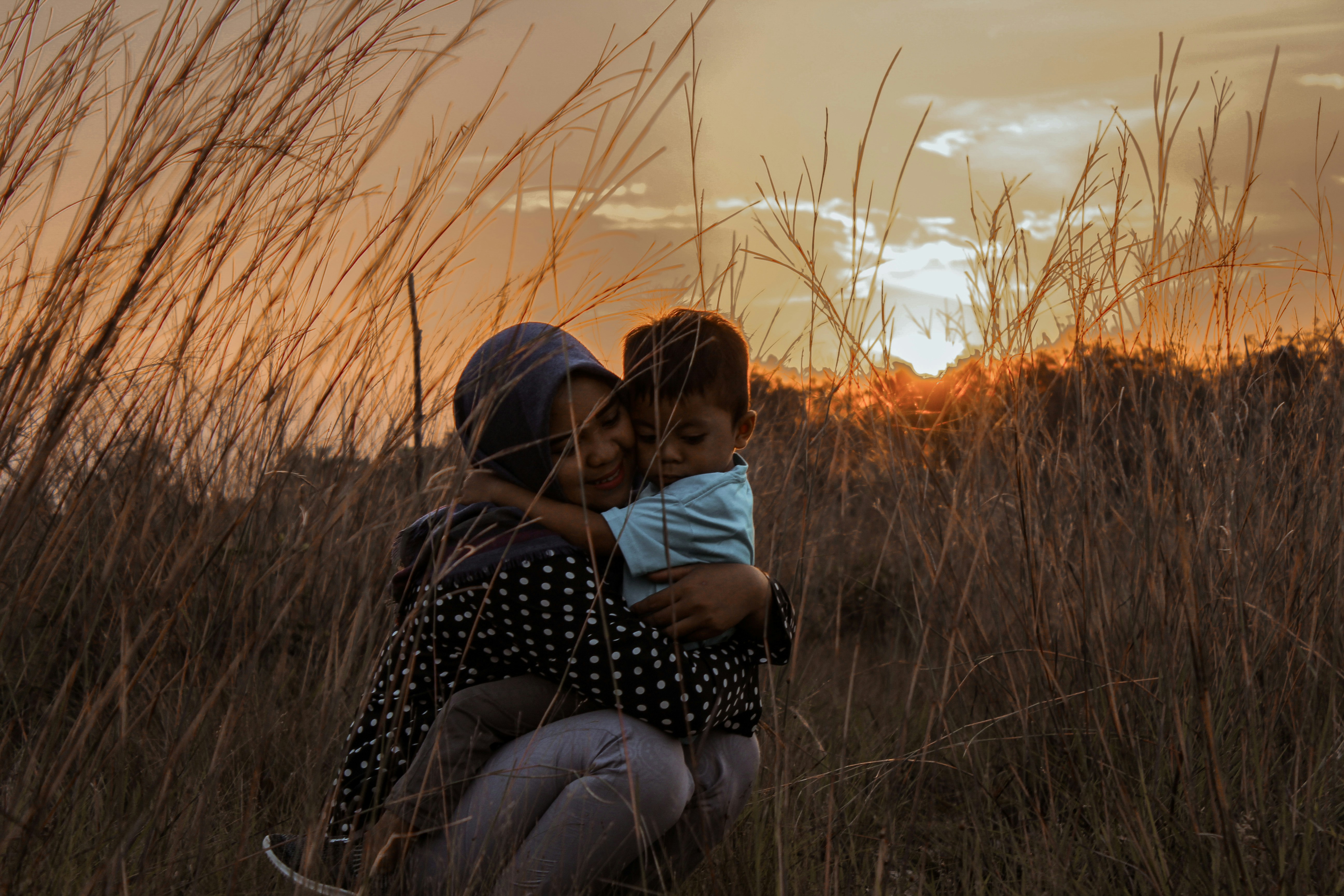 En inspirerande bild av en mor och ett barn mot en vacker solnedgång eller landskap.