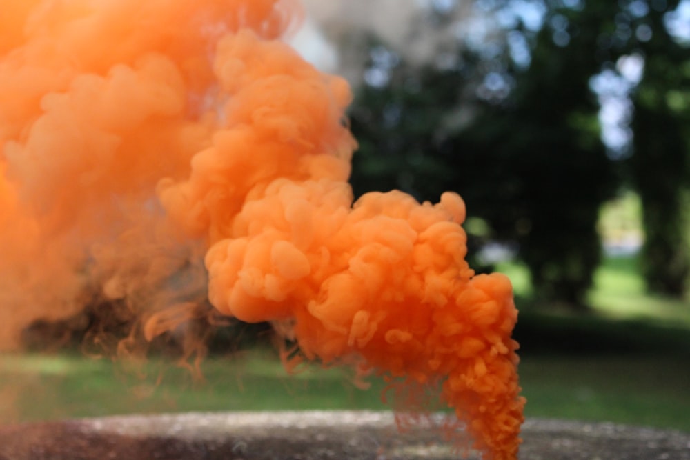 a large orange cloud of smoke coming out of a pipe