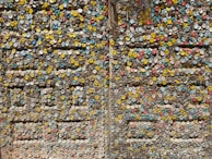 A vibrant display of useful items made entirely from recycled plastic caps, arranged on a table.
