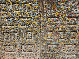 A vibrant display of useful items made entirely from recycled plastic caps, arranged on a table.