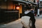 woman in black and white floral kimono walking on sidewalk during daytime