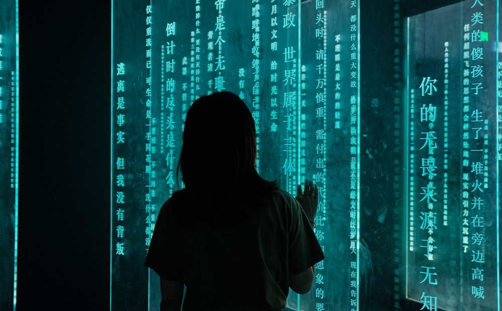 silhouette of woman standing in front of blue light