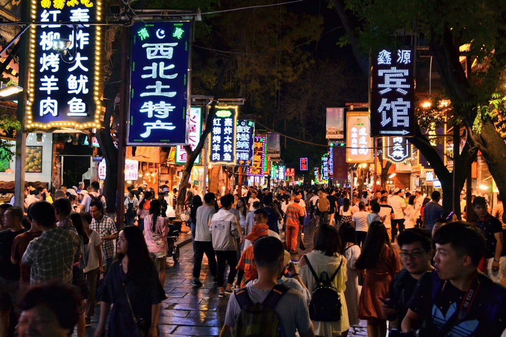 persone che camminano per strada durante la notte