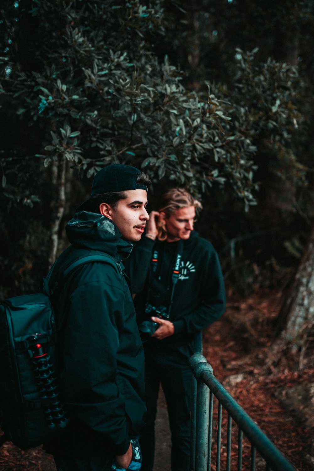 man in green hoodie standing beside man in black knit cap