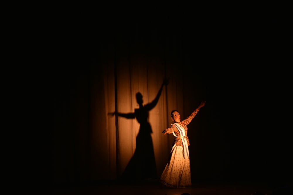 Frau im weißen Kleid tanzt auf der Bühne