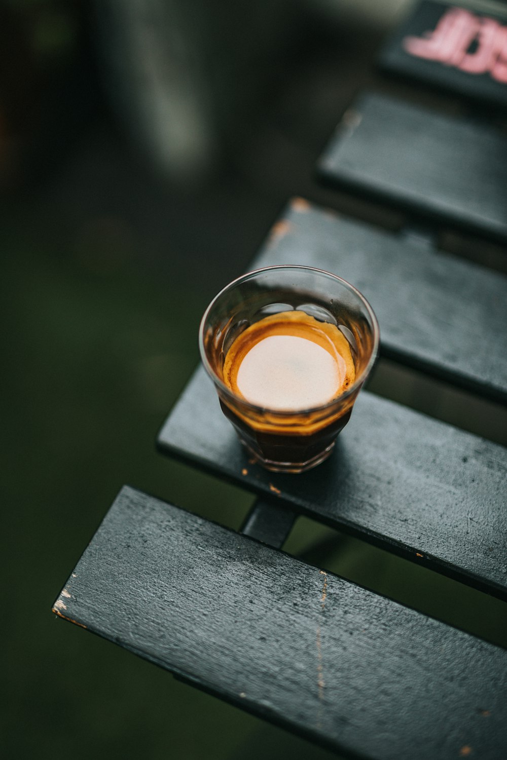 a glass of liquid sitting on top of a wooden table