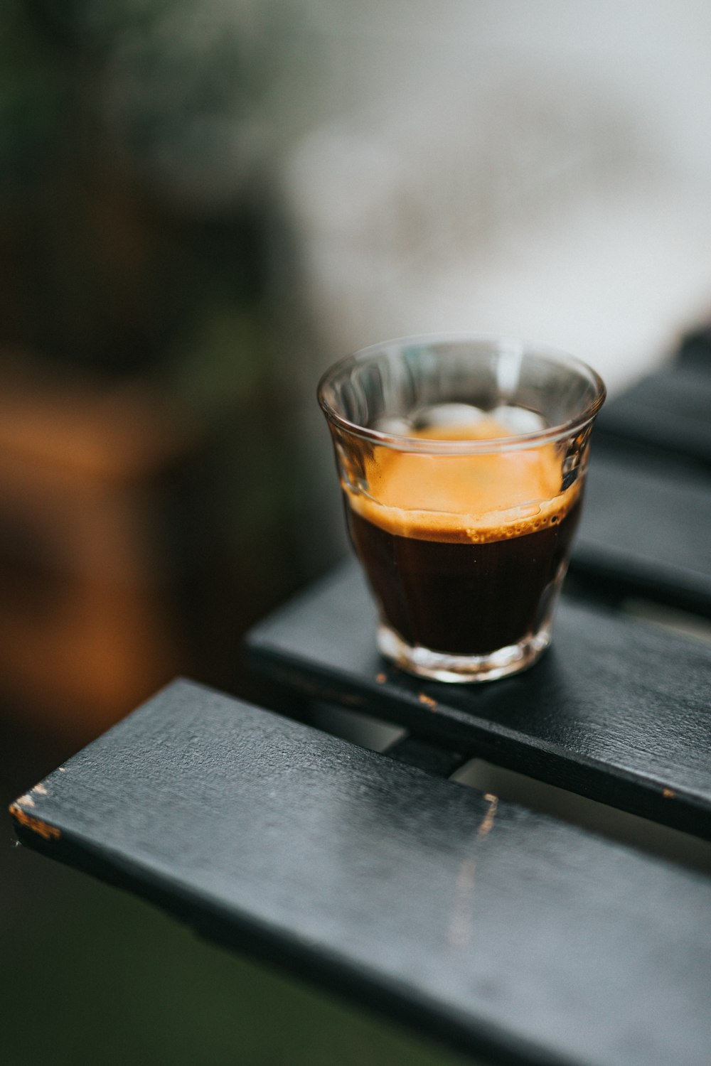 clear drinking glass with brown liquid on black table