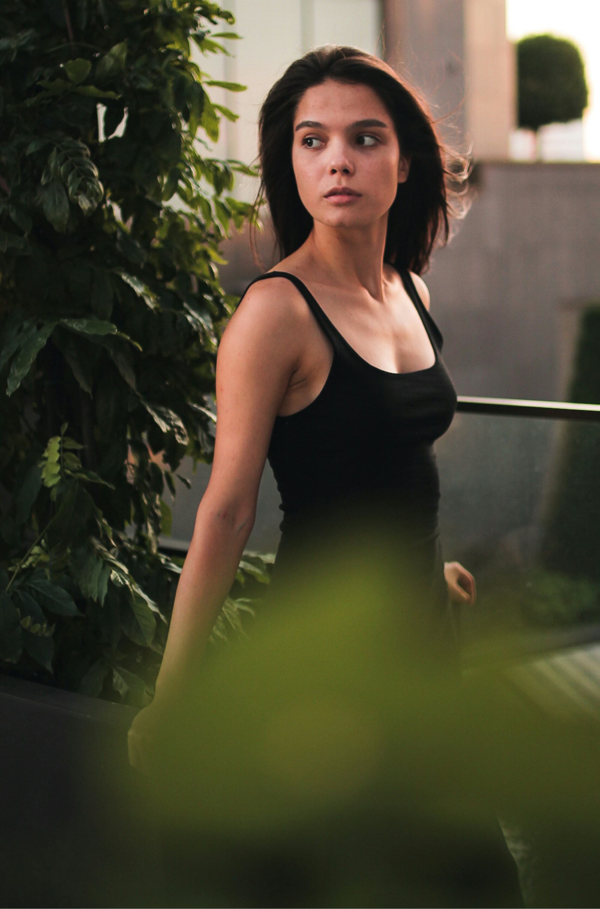 緑の植物のそばに立っている黒いタンクトップの女性の写真 Unsplashで見つけるティミショアラの無料写真