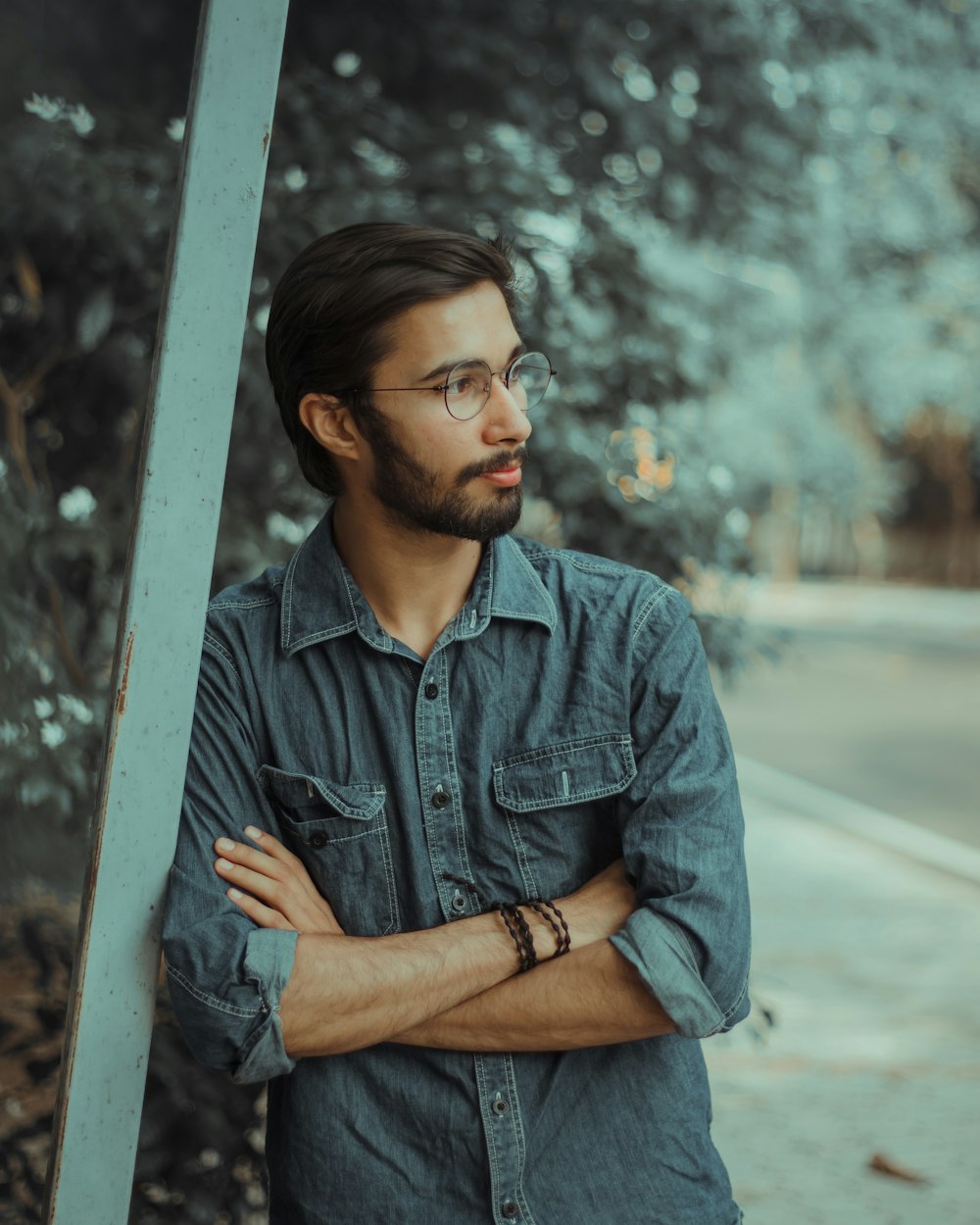 man in blue dress shirt sitting on sidewalk during daytime